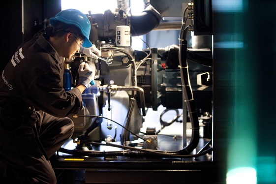 Atlas Copco certified technician performing compressor service maintenance